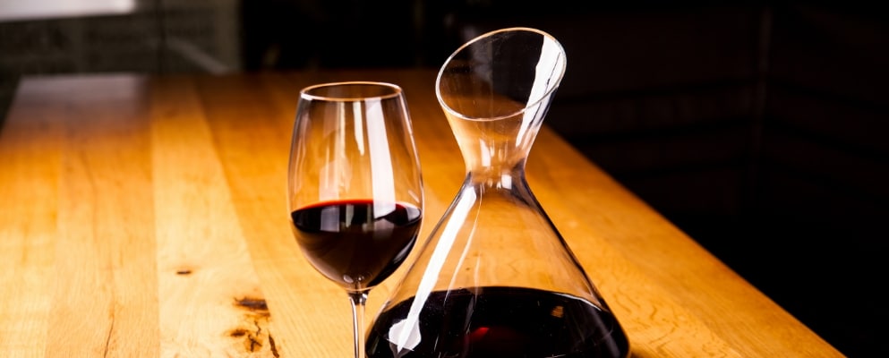 a wine decanter & wine glass with red wine in them