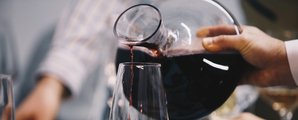 red wine being poured from a wine decanter